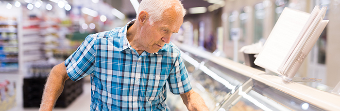 Shopper selecting food from supermarket fridge